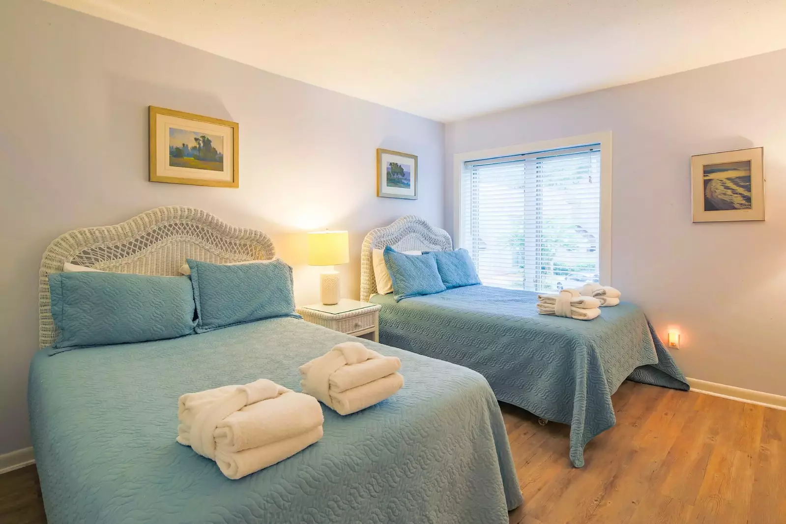 The Guest Suite features two full beds and a night stand with a reading lamp.