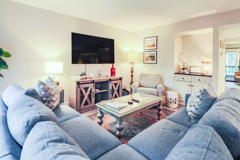 Sit back and relax in our comfortable living room with a spacious sectional sofa and wall-mounted TV.