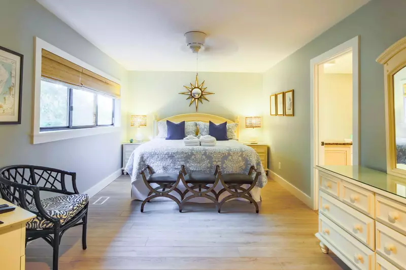 The master suite also features a dresser, ceiling fan and an en suite bathroom.