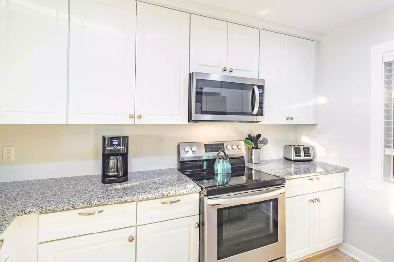 The kitchen features an electric range, microwave, toaster and drip coffee maker.