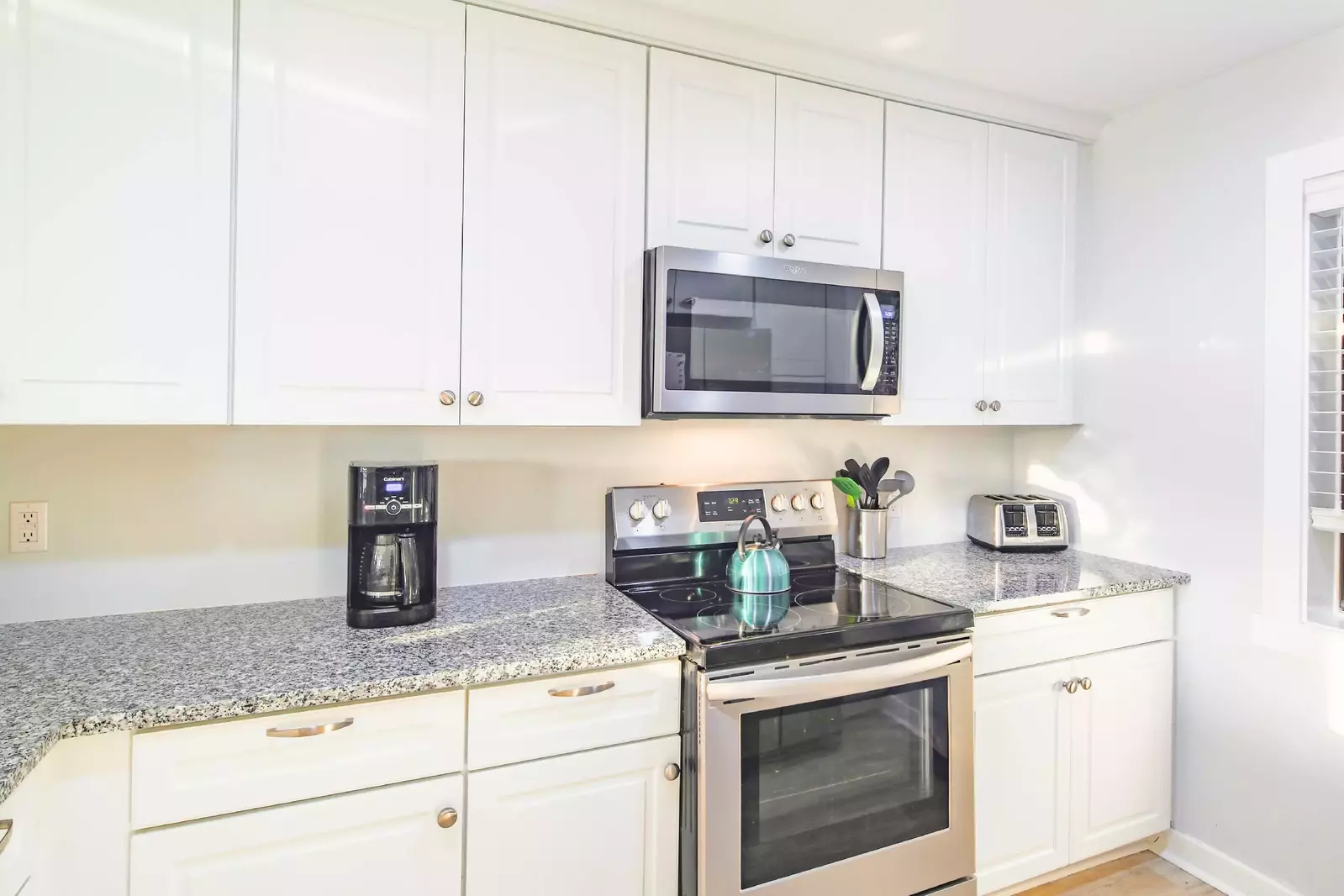 The kitchen features an electric range, microwave, toaster and drip coffee maker.
