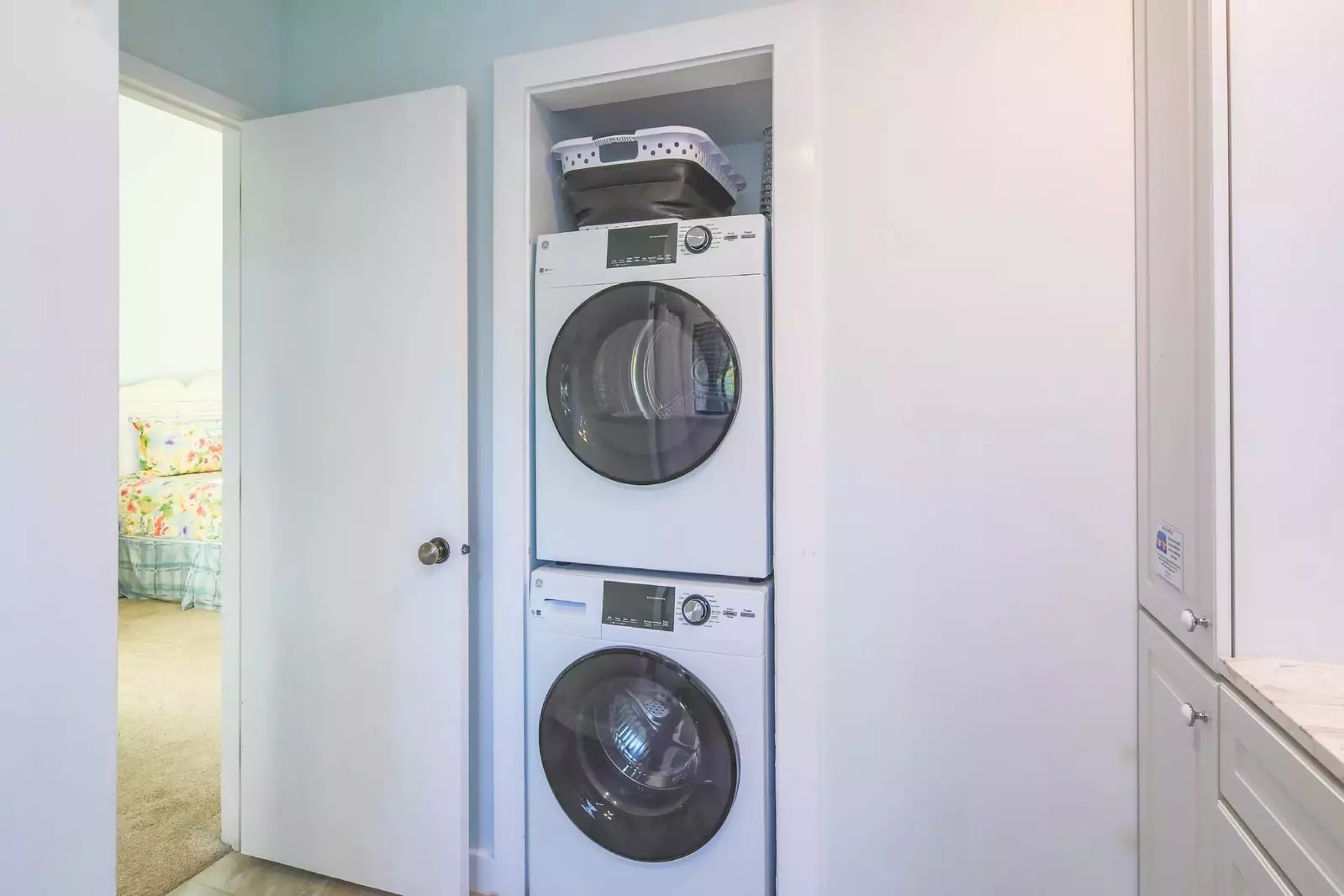 The stacked washing machine and dryer are located within the master bathroom.