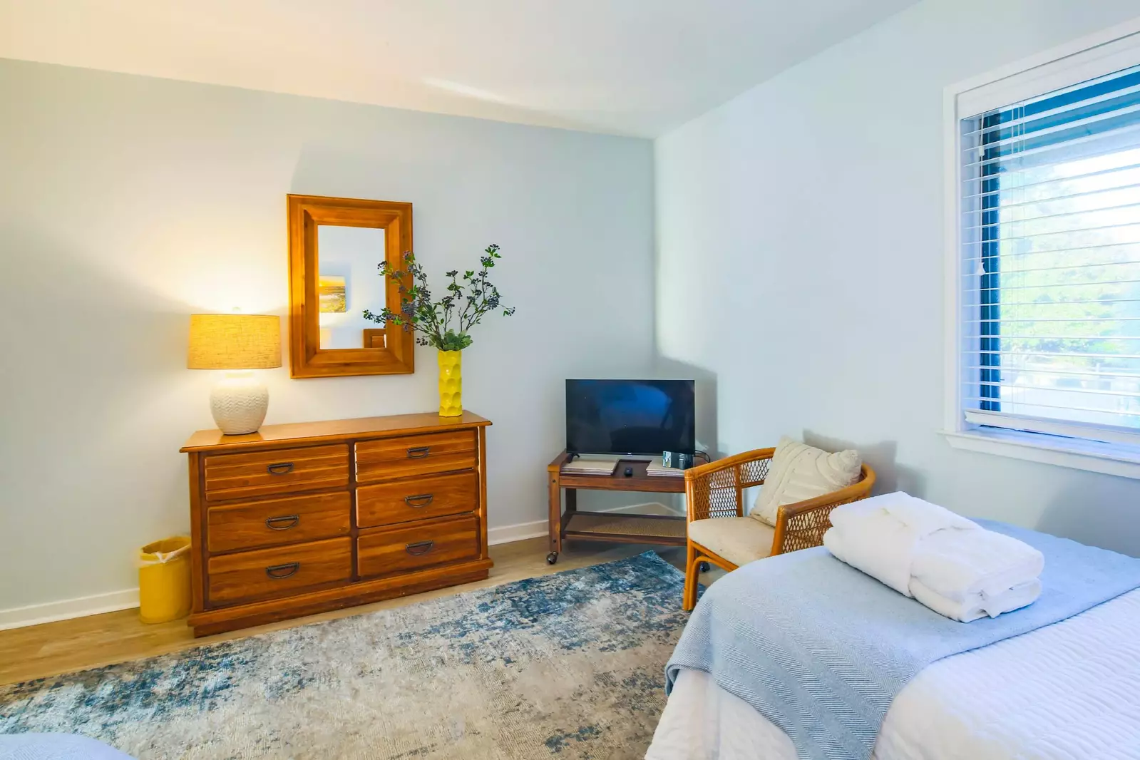This twin suite features a dresser, arm chair and TV.