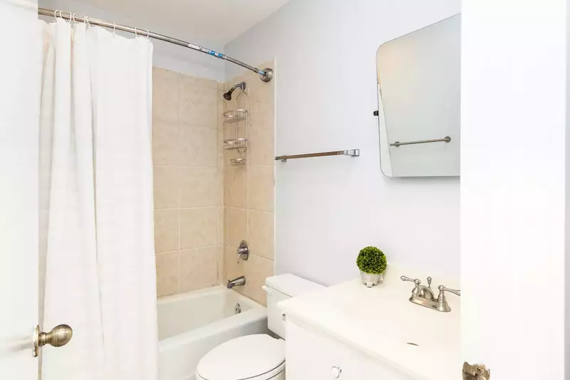 This bathroom features a spacious vanity and a tiled, shower/tub combo.