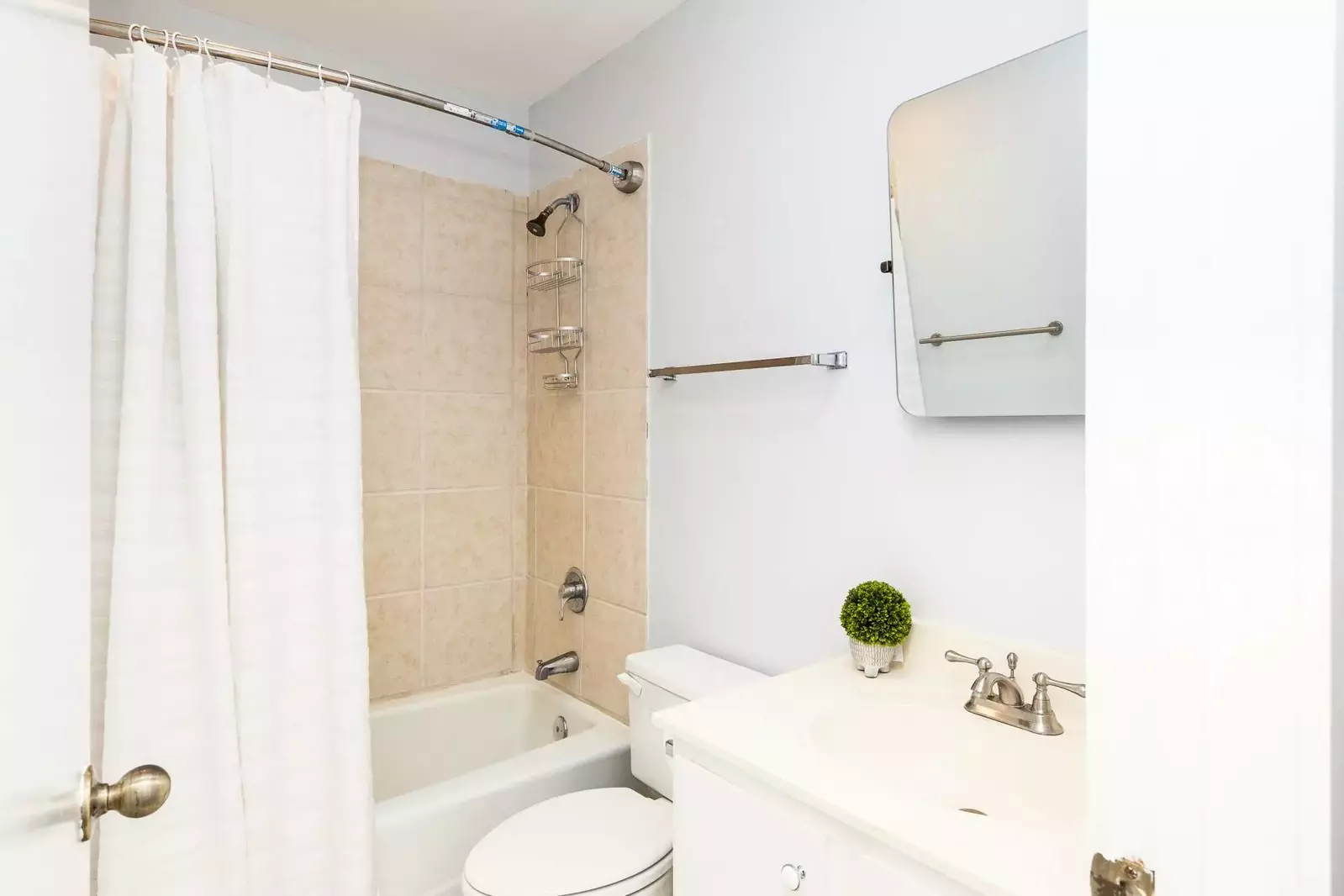 This bathroom features a spacious vanity and a tiled, shower/tub combo.