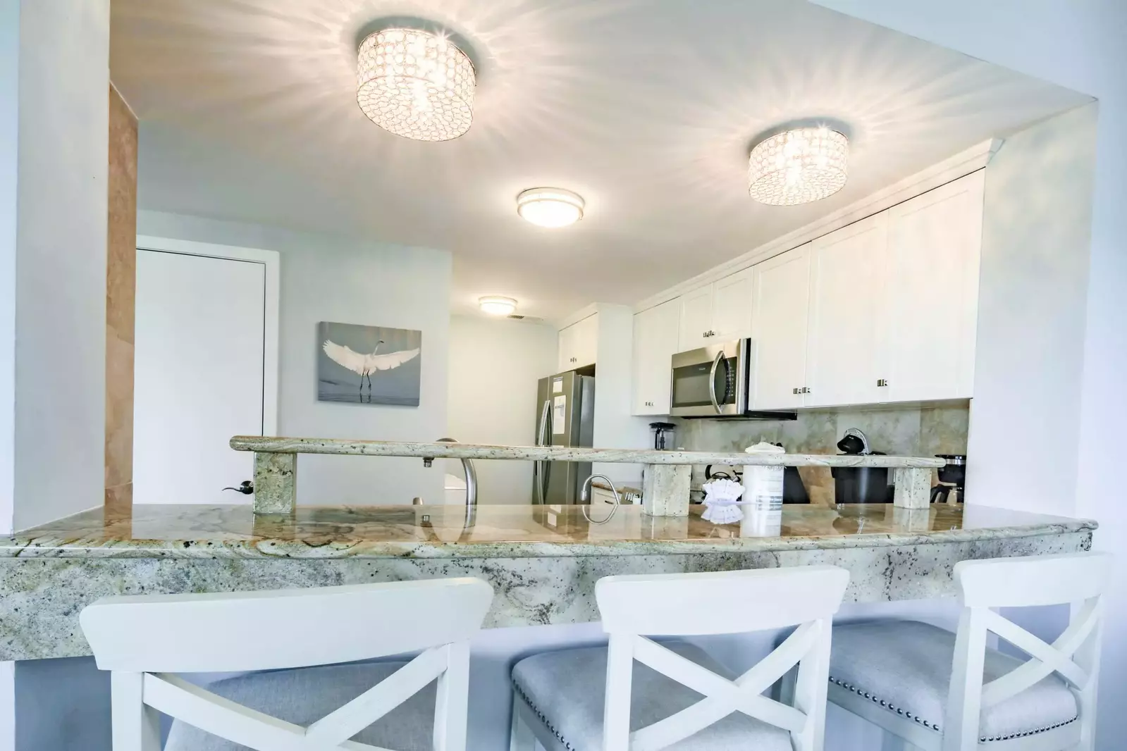 The renovated kitchen features granite counters, stool seating and stainless steel appliances.