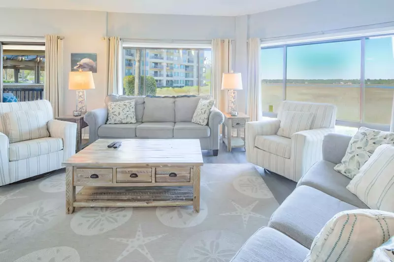 The living room features stunning marsh views and a spacious seating area.
