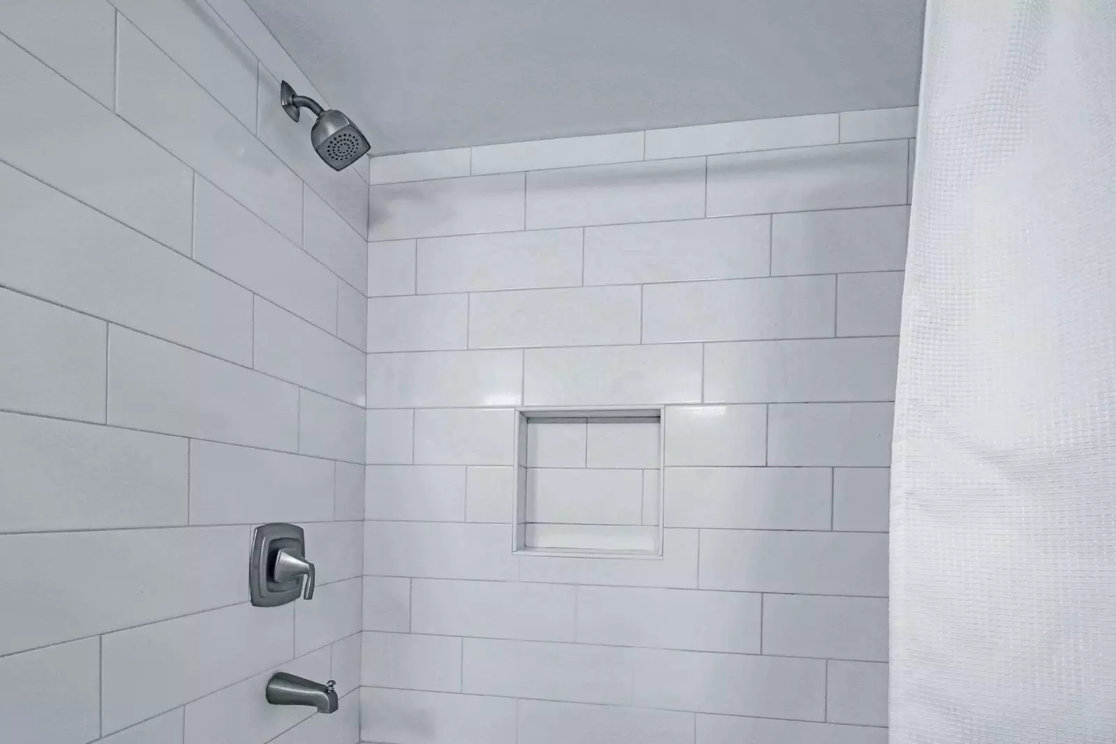 This en suite bathroom also has a tiled shower/tub combo.