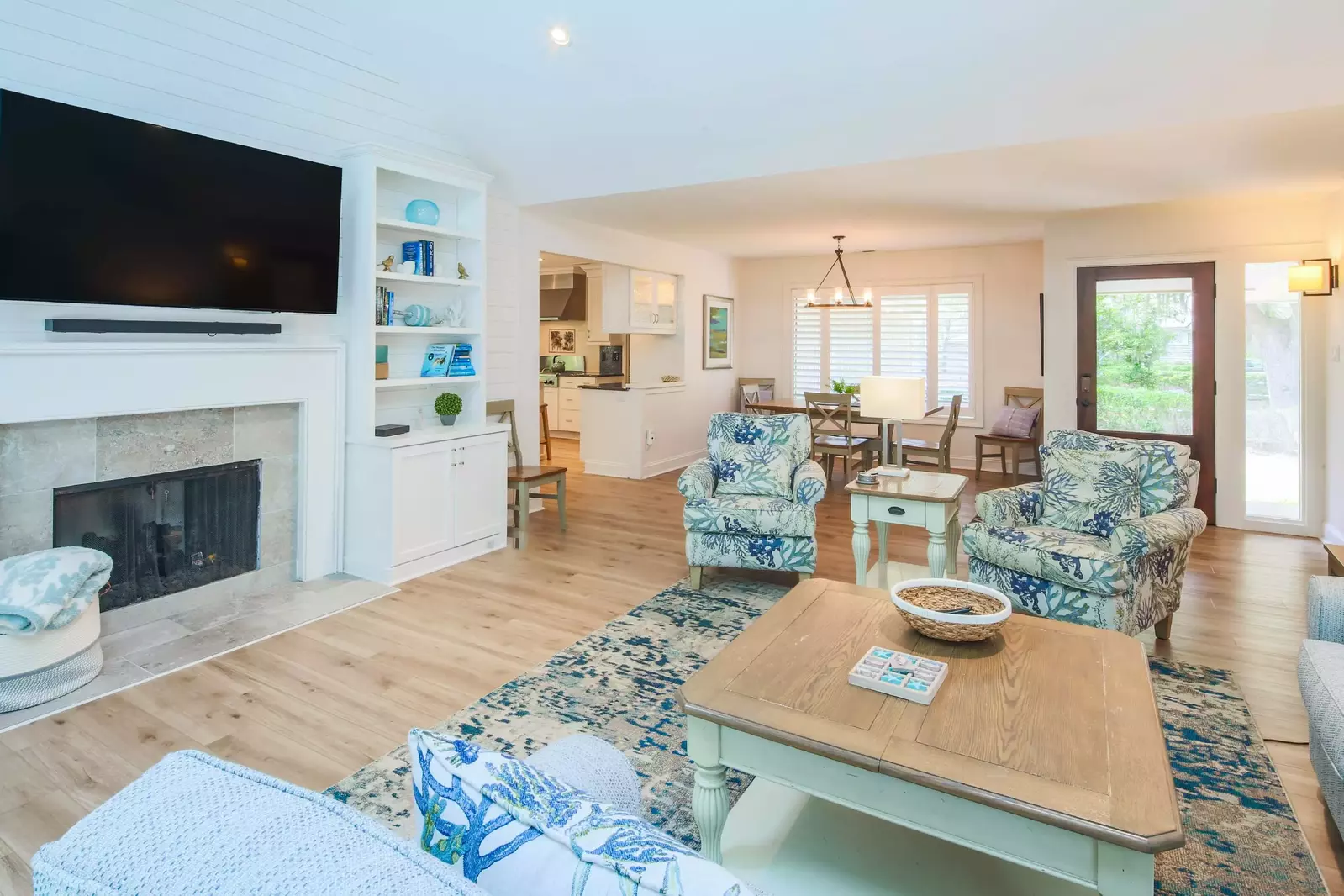 The living room features vaulted ceilings, shiplap accent walls and a wall-mounted TV.