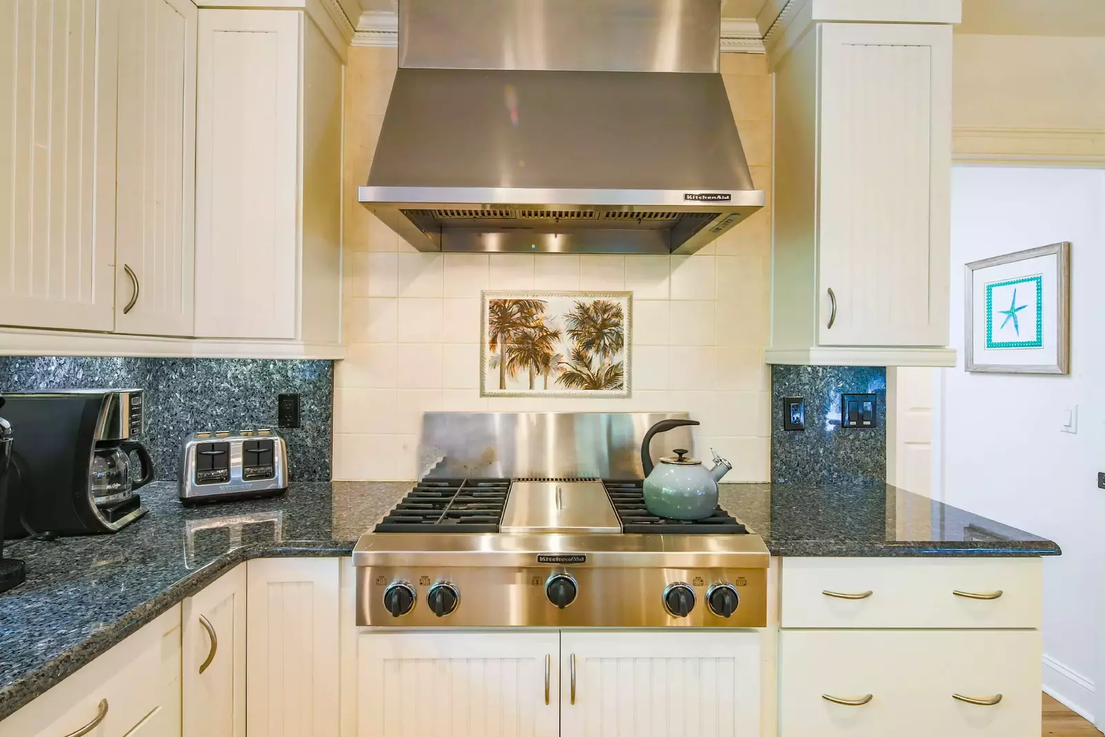 The kitchen features a gas cooktop and hood.