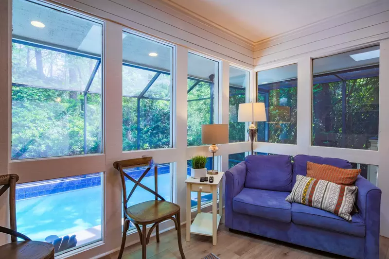 This sitting area near the back door features shiplap walls and views of the private pool.