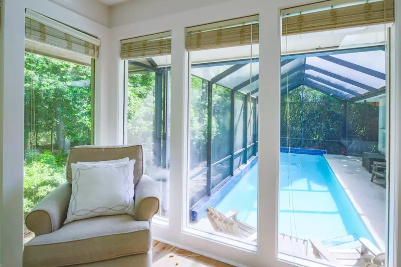 The master suite also features an arm chair and views of the home's private pool.