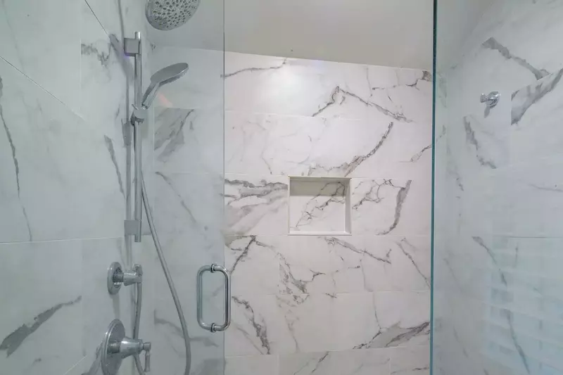 The en suite bathroom also has a beautifully tiled walk-in shower with two shower heads.