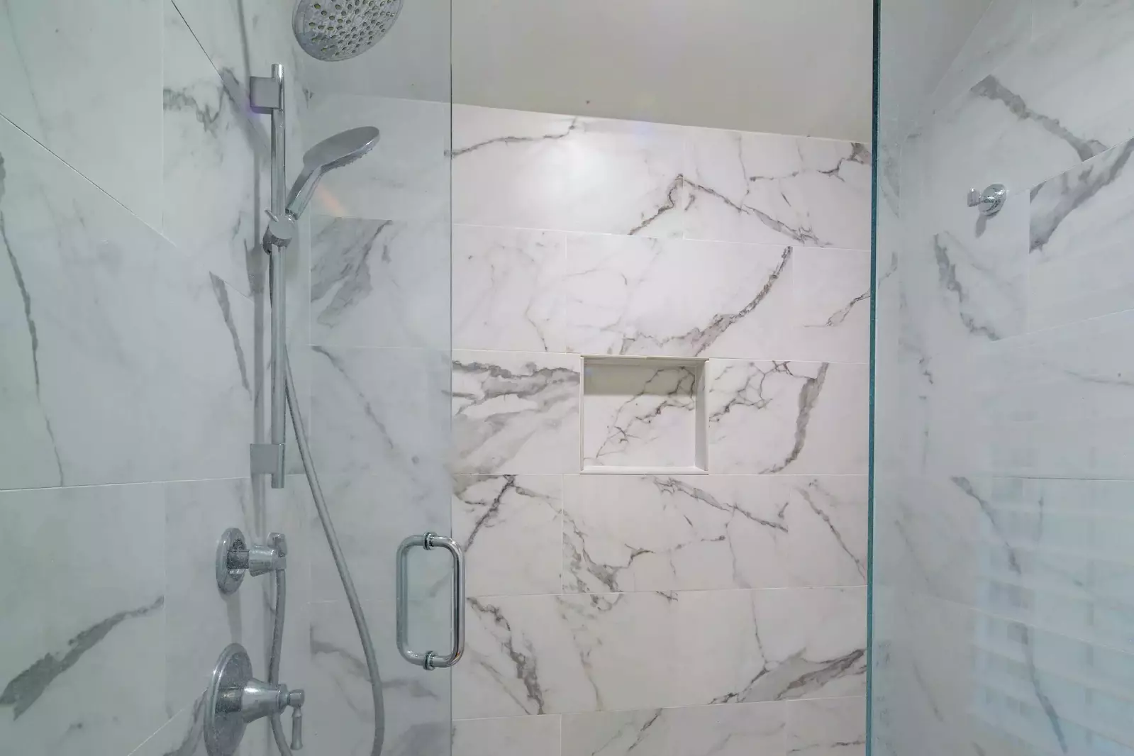 The en suite bathroom also has a beautifully tiled walk-in shower with two shower heads.