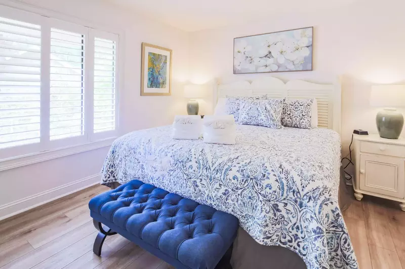The second master suite features a king bed and night stands with reading lamps.