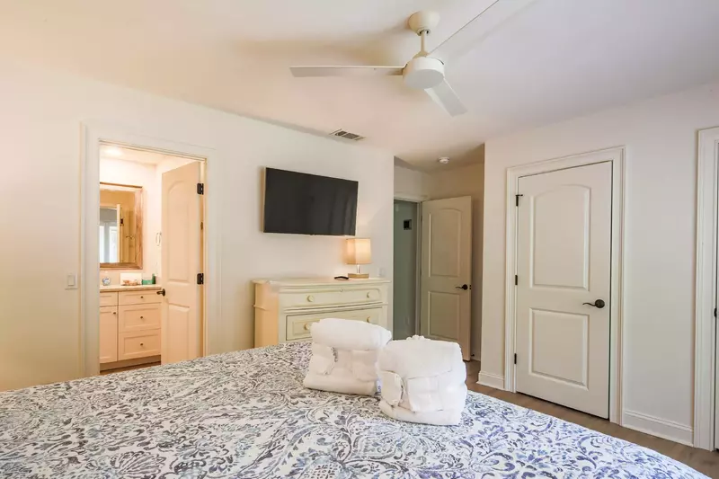The second master suite also has a dresser, wall-mounted TV and en suite bathroom.