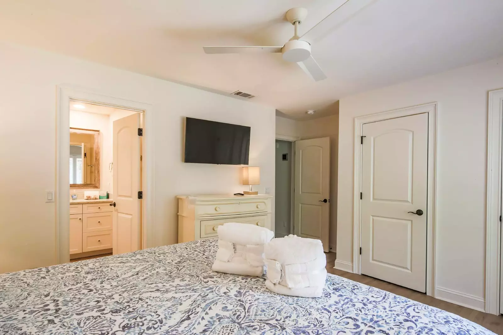 The second master suite also has a dresser, wall-mounted TV and en suite bathroom.