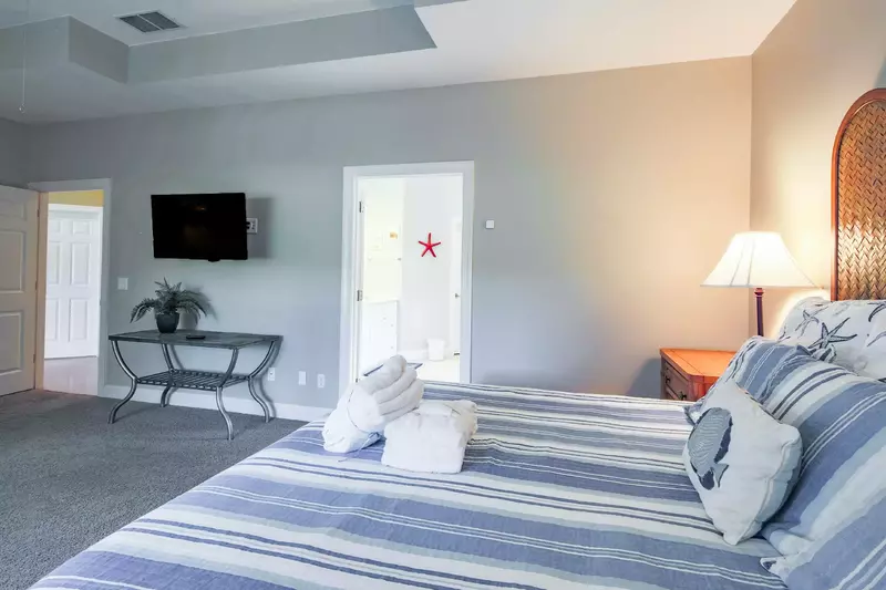 The en suite bathroom is just through the door near the bed and wall-mounted TV.