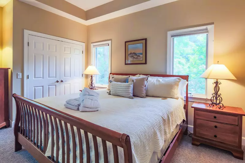 The second master suite features a king bed and night stands with reading lamps.