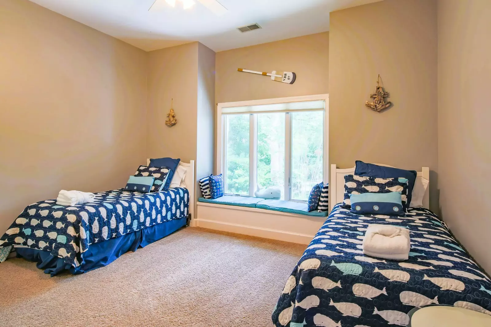 This bedroom features two twin beds and a built-in window seat.