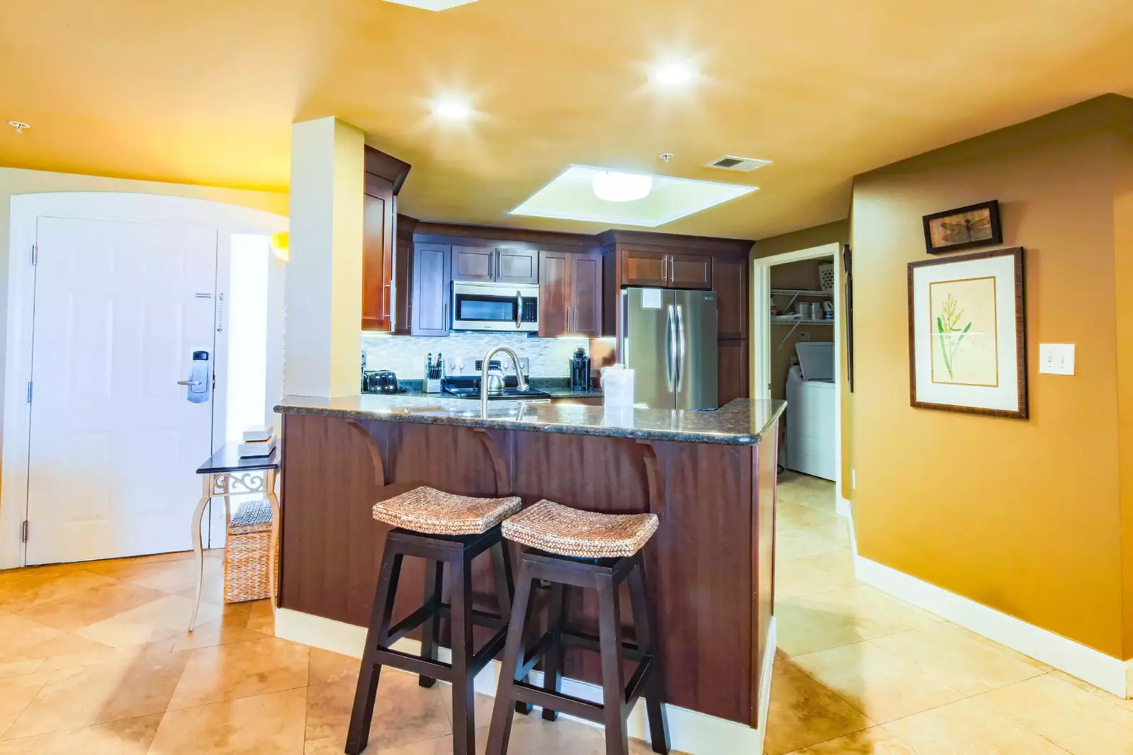 There are two stools on the dining area side of the kitchen counter.