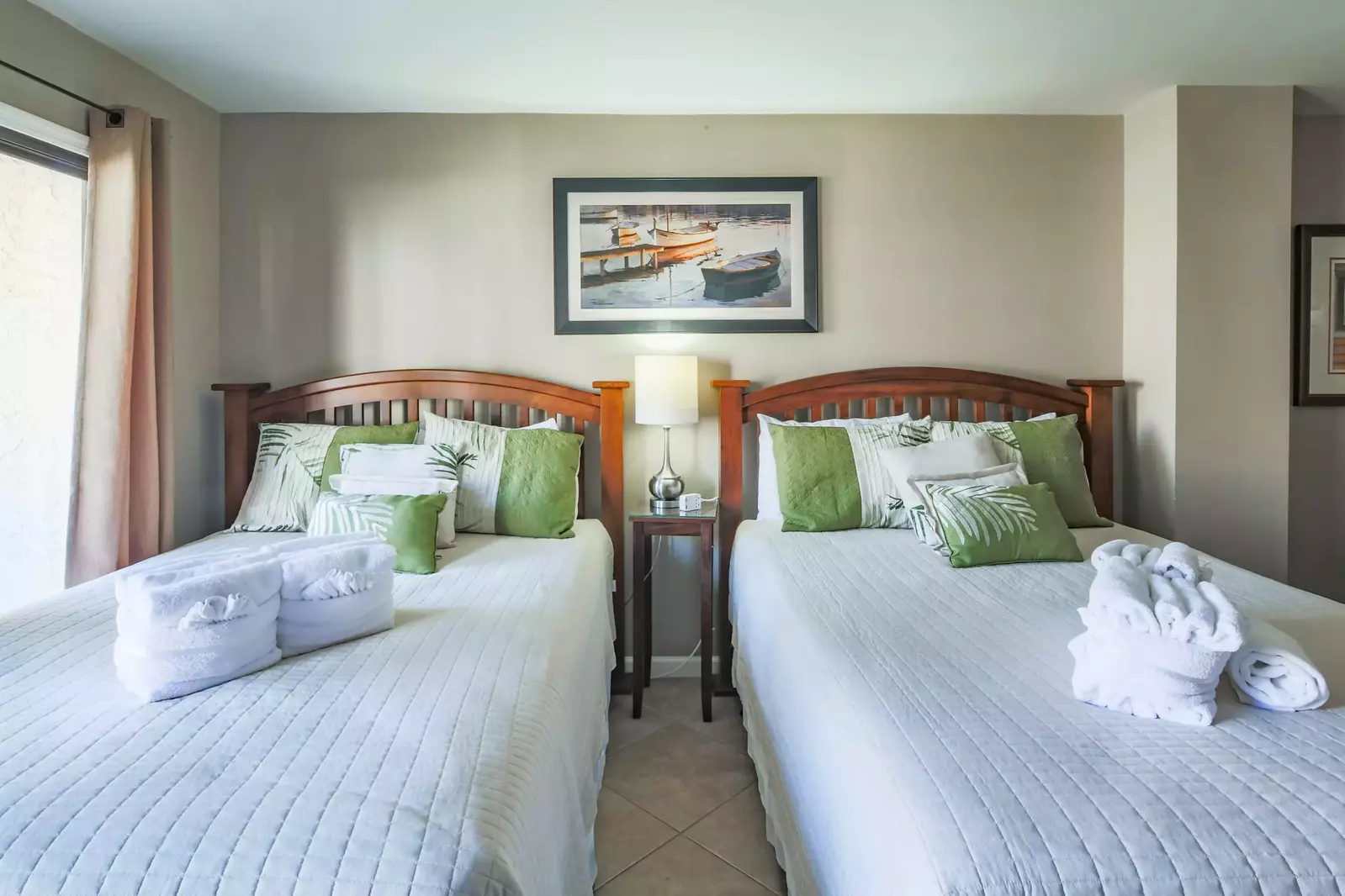 The guest suite features two queen beds and a night stand with reading lamp.
