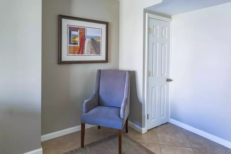 There is an arm chair near the closet in the guest suite.