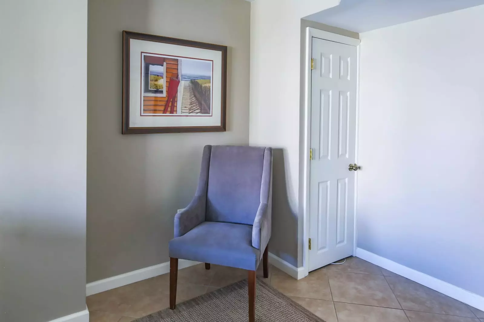 There is an arm chair near the closet in the guest suite.