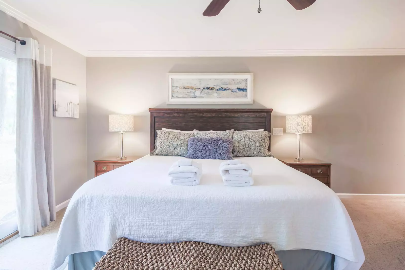 The first master suite features a king bed and night stands with reading lamps.