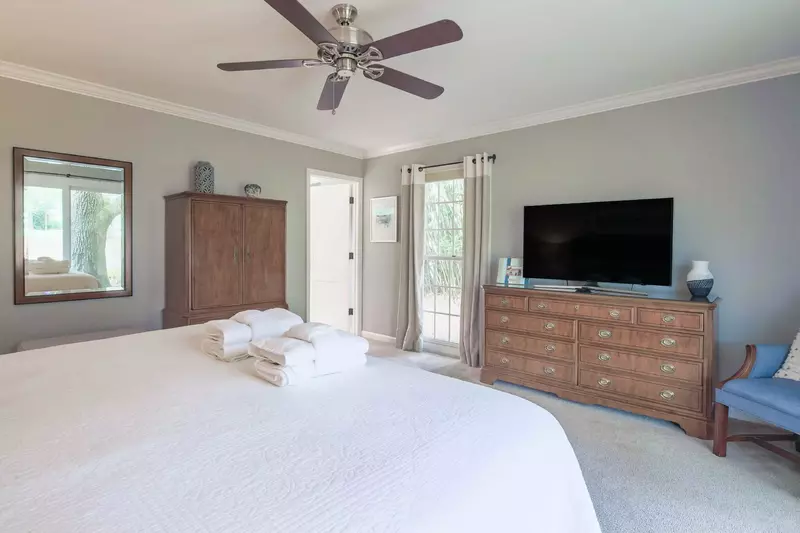 The first master suite also has an arm chair, dresser with flat screen TV, armoire and en suite bathroom.