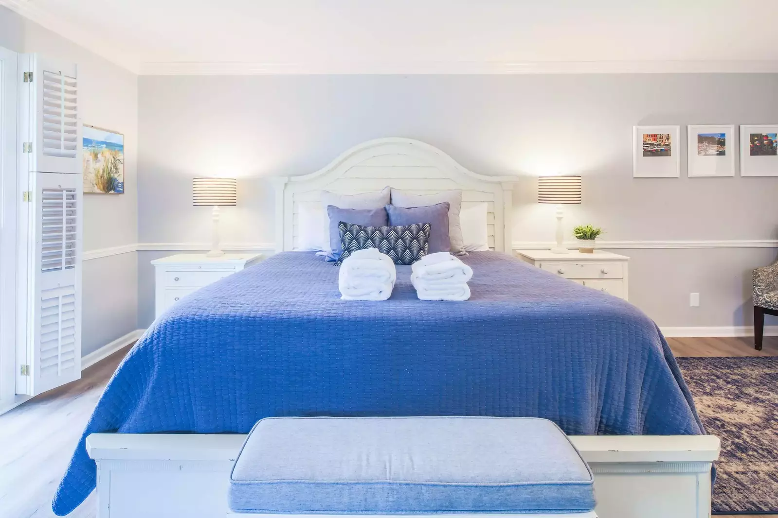 The second master suite features a king bed, night stands with reading lamps and a bench.