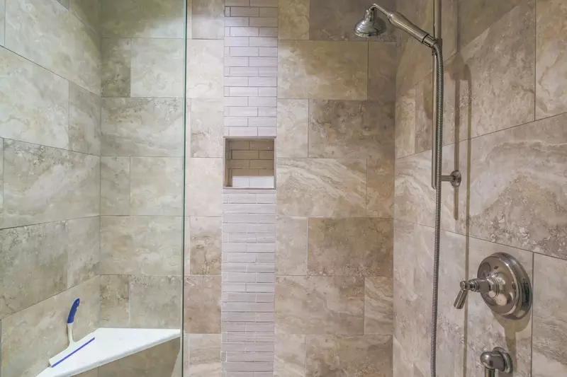The en suite bathroom also has a beautifully tiled, walk-in shower with two shower heads.