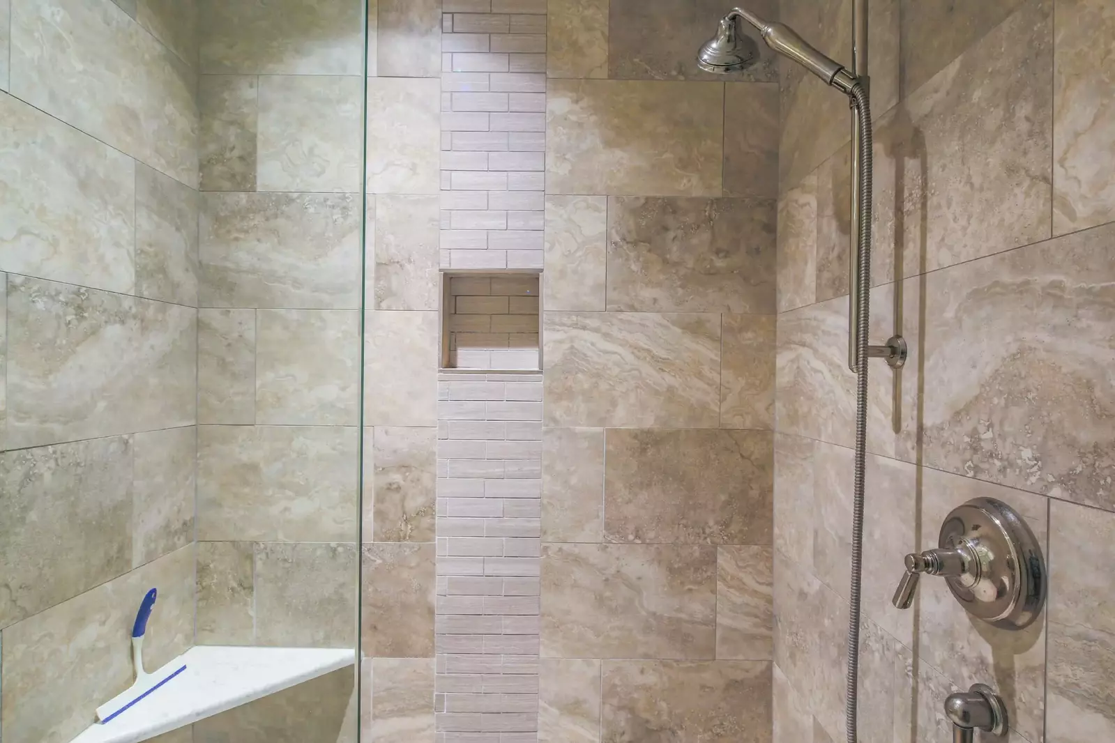 The en suite bathroom also has a beautifully tiled, walk-in shower with two shower heads.
