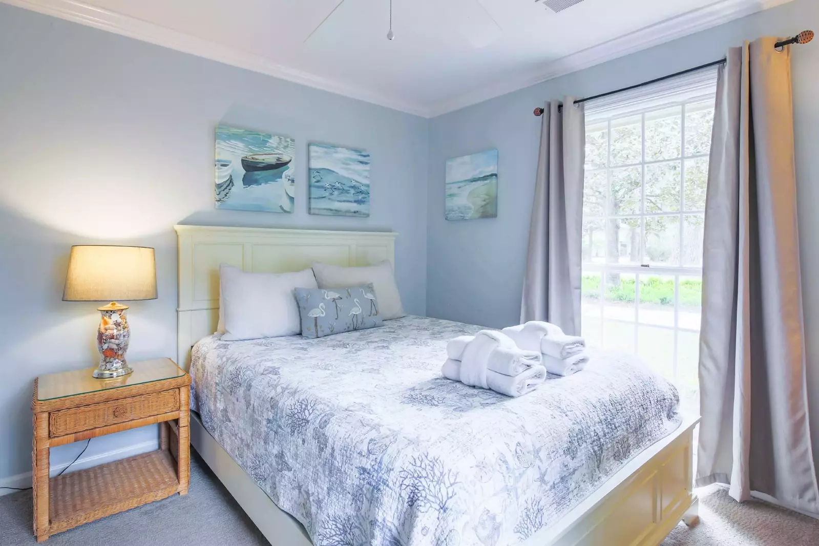 This guest bedroom features a queen bed and night stand with reading lamp.