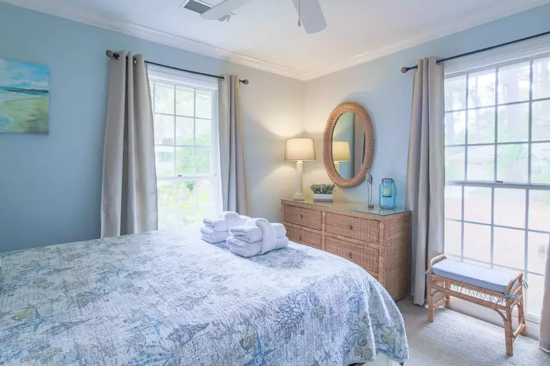 The queen guest bedroom also has a dresser, ceiling fan and bench.