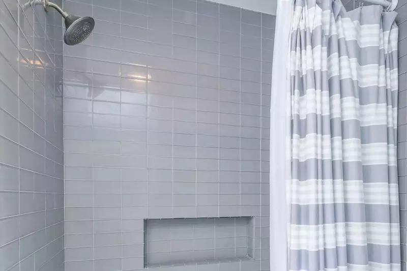 The hallway bathroom also has a tiled, shower/tub combo.