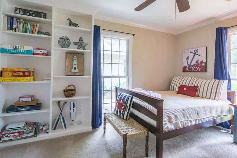 This guest bedroom also has a built-in bookshelves, bench and ceiling fan.