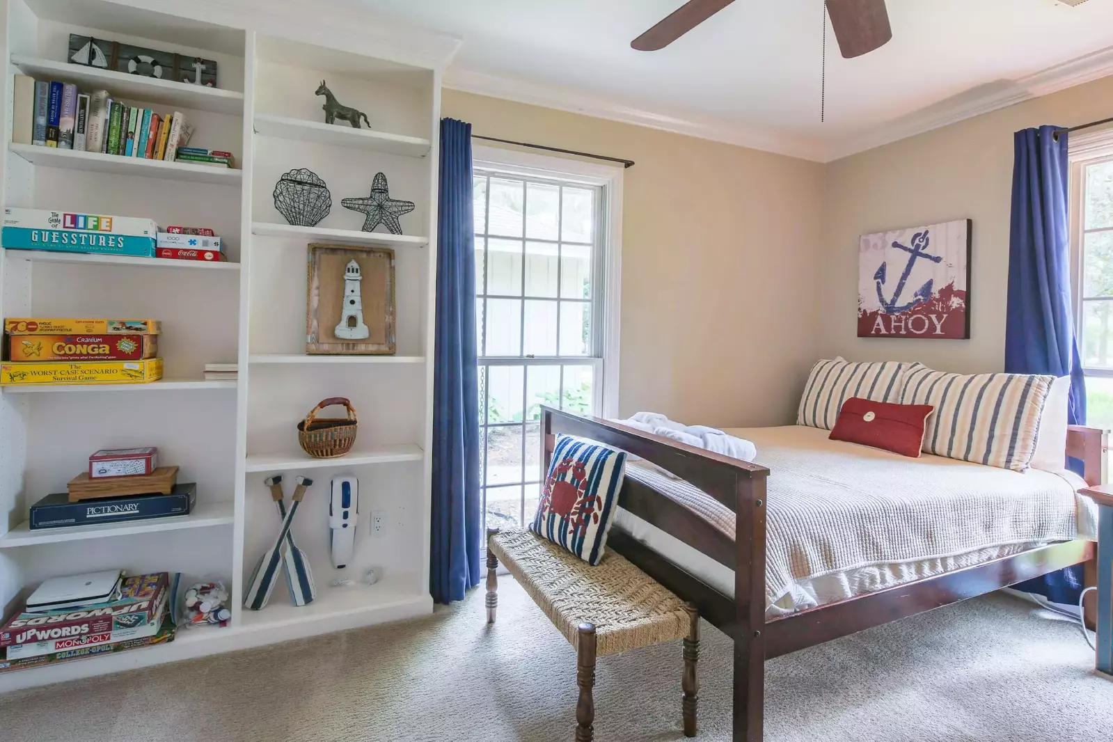 This guest bedroom also has a built-in bookshelves, bench and ceiling fan.