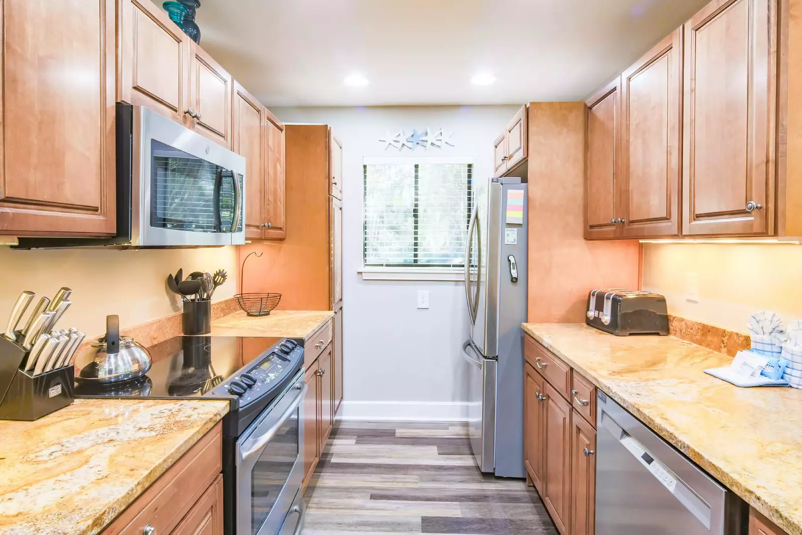 The kitchen features a dishwasher, refrigerator, range, microwave and toaster.