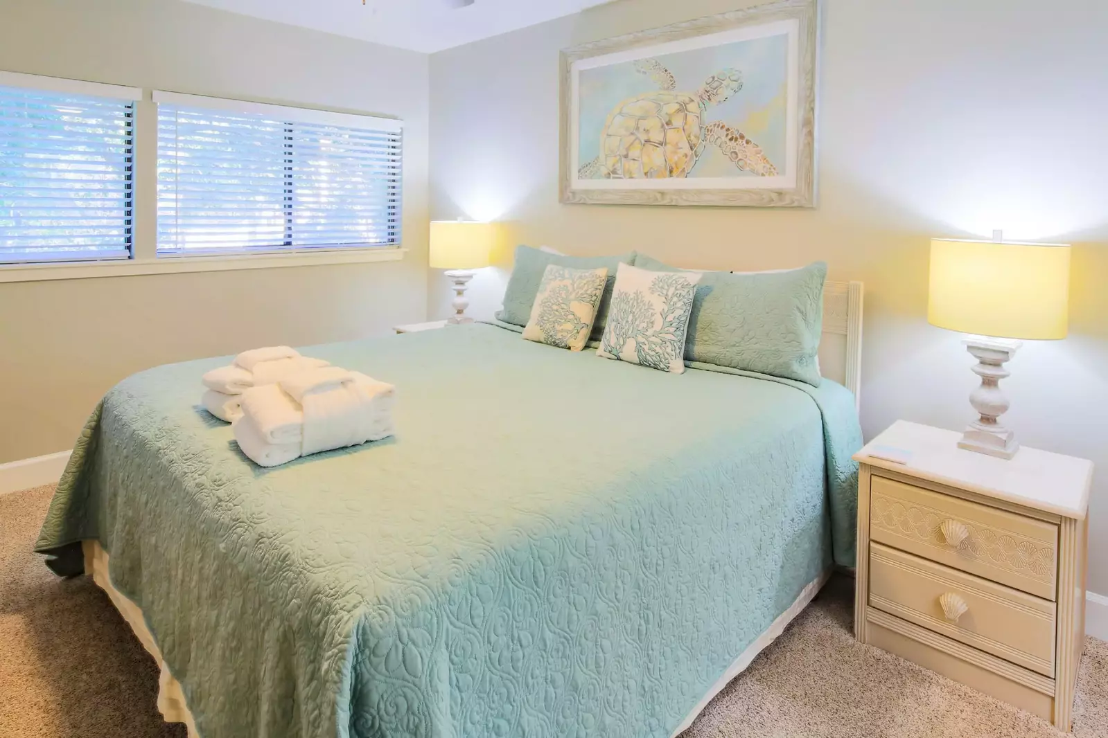 The master suite, which is located on the upper level, features a king bed and night stands with reading lamps.