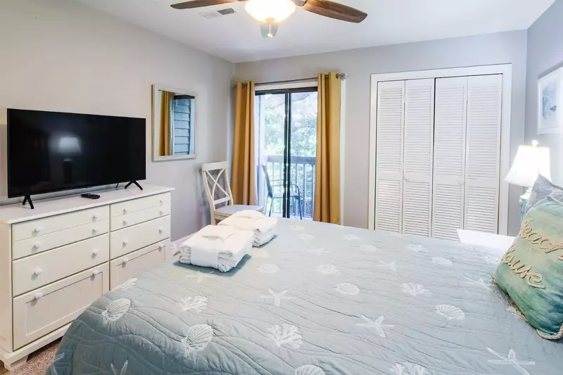The Queen Suite also has a dresser with flat screen smart TV, a ceiling fan and closet.