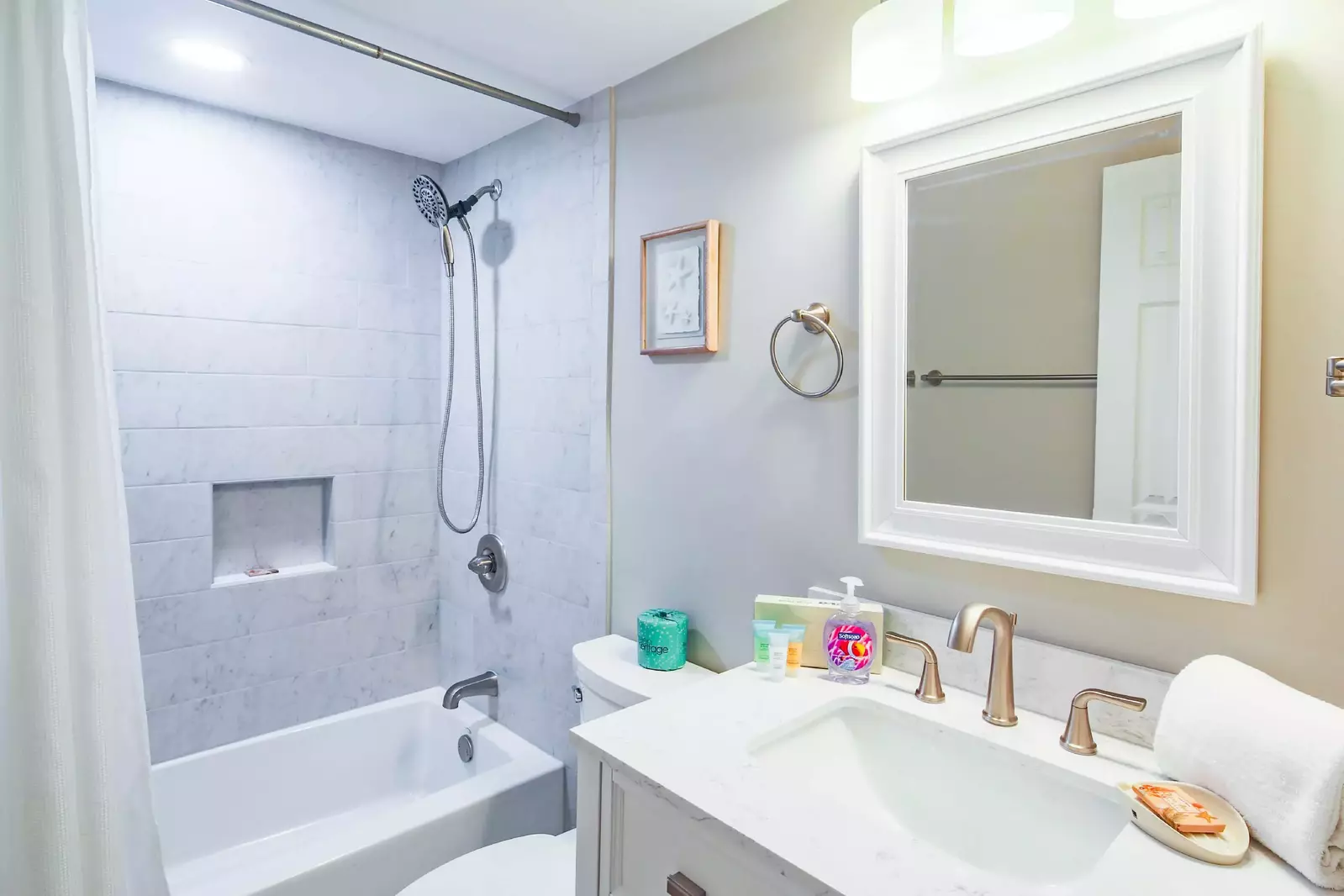 This en suite bathroom also has a beautifully tiled shower/tub combo.