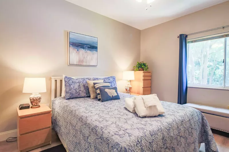 The bedroon features a queen bed and nightstands with reading lamps.