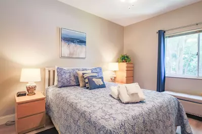 The bedroon features a queen bed and nightstands with reading lamps.