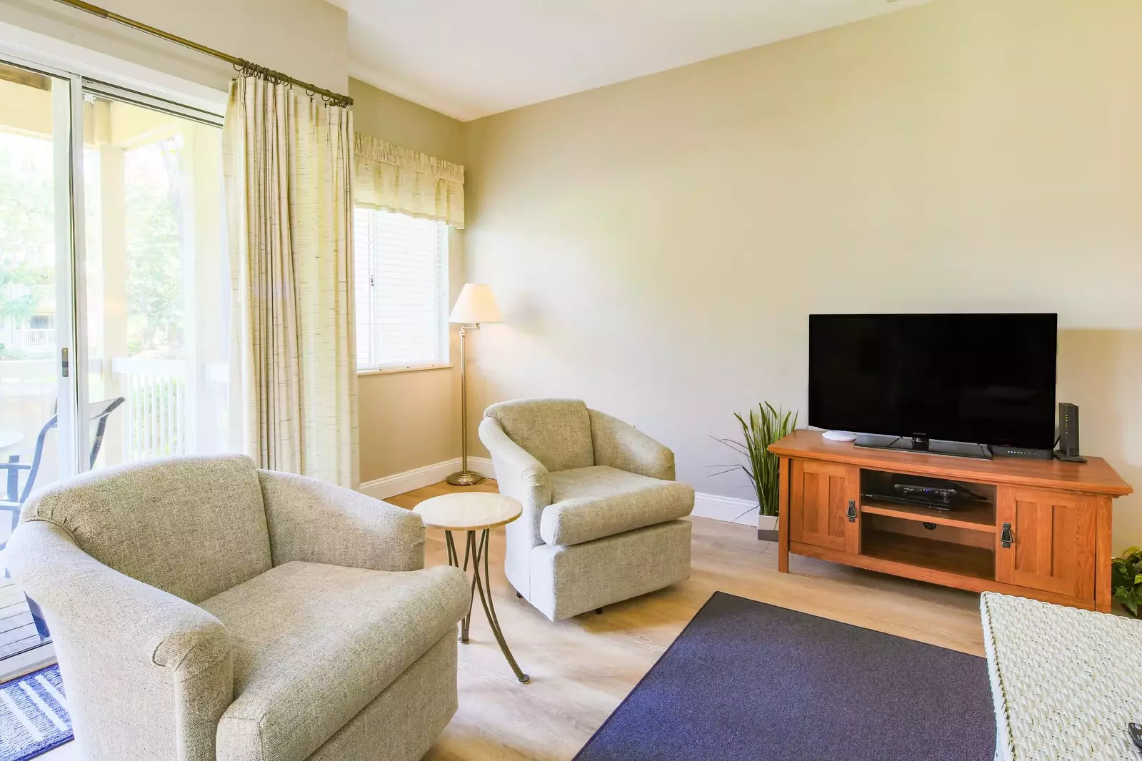 There is a TV, seating area and sliding glass door to the covered balcony in the living room