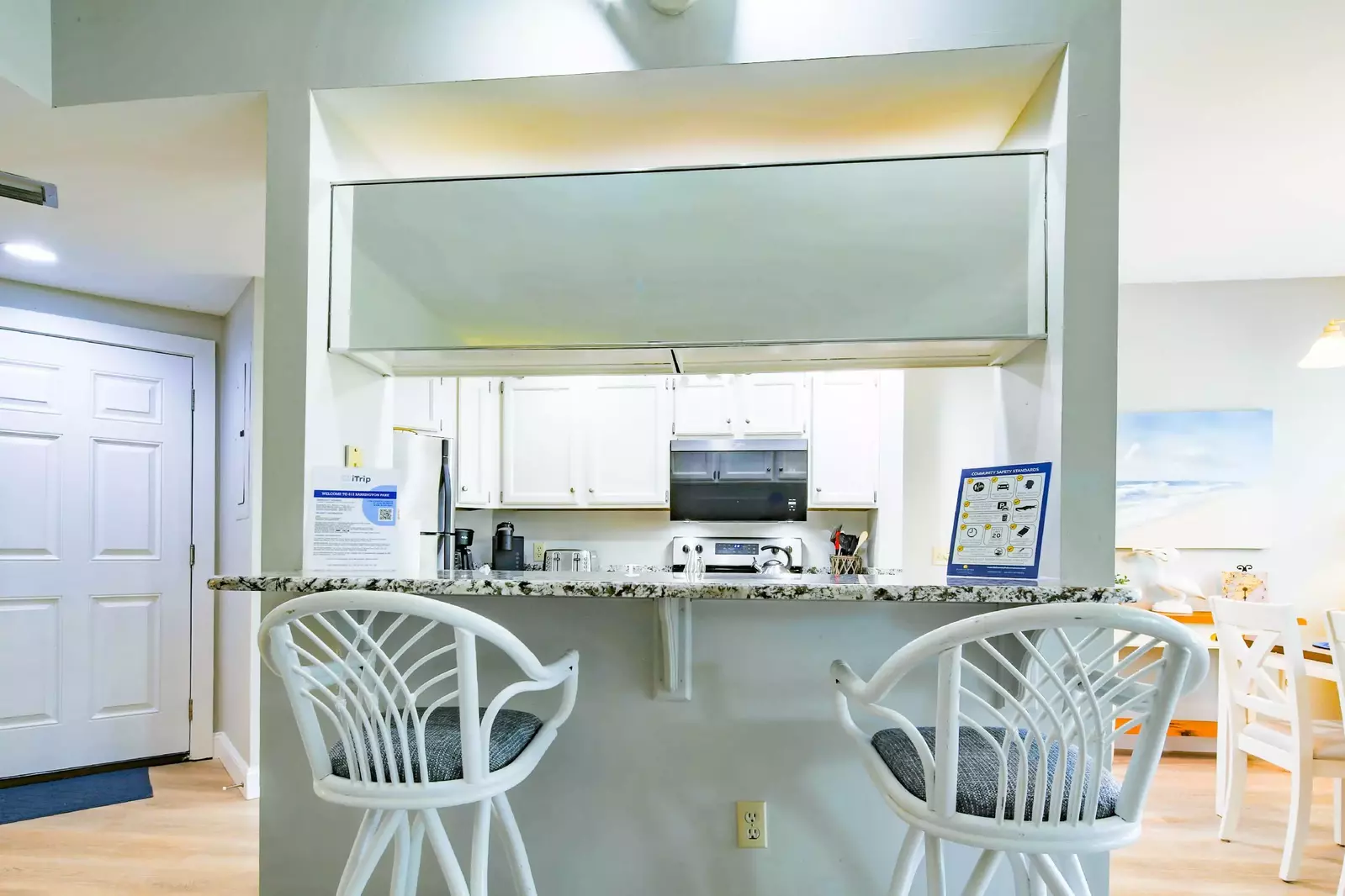 There are two stools on the living room side of the kitchen counter.
