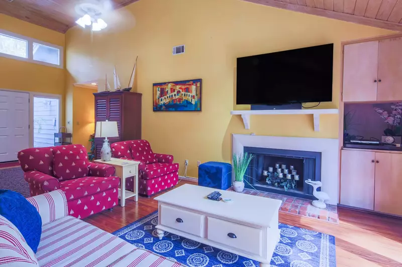 The living room features a wall-mounted TV and decorative fireplace (not available for guest use).