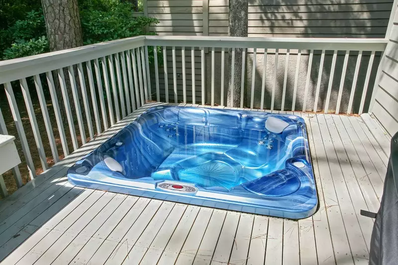 The private hot tub is located on the back deck near the sliding glass door to the dining area.
