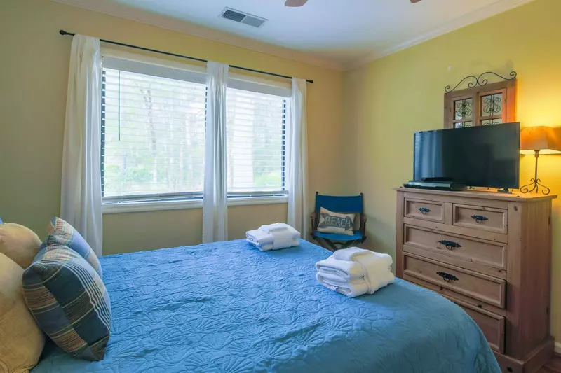 This guest bedroom also has a dresser, ceiling fan and flat screen TV.