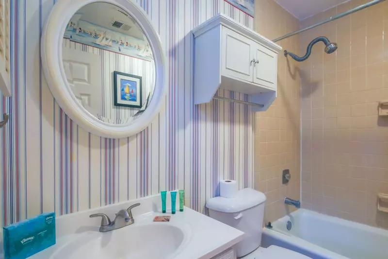 This hallway bathroom features a vanity and shower/tub combo.